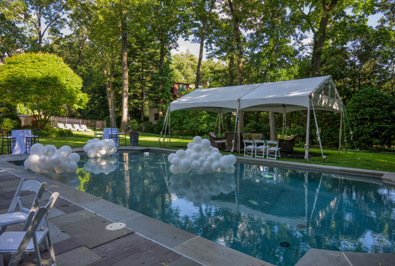 Pool with balloon decoration and party tent