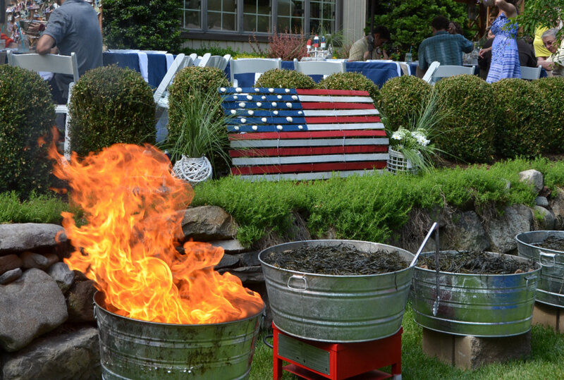 Three barrels with seafood in front of wooden American flag decoration