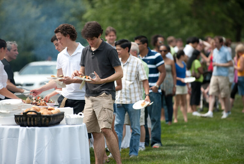 Long long of party guests being served at tables